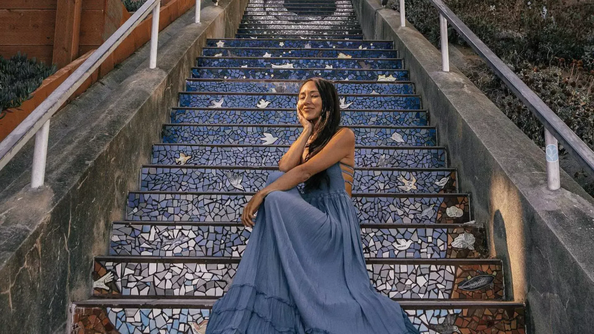 一个女人坐在贝博体彩app日落区第16大道的瓷砖楼梯上。.