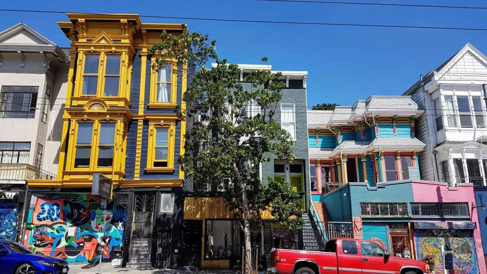 Vue sur les bâtiments colorés de Haight Street avec des voitures garées le long de la rue. San Francisco, Californie.