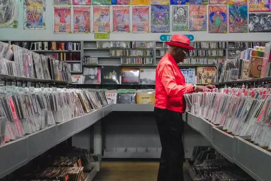 Um homem de jaqueta vermelha 和pra discos na Amoeba Records, 在贝博体彩app.