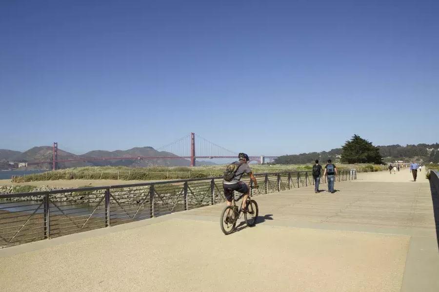 A man rides A bike along A trail at Crissy Field. 圣弗朗西斯科，加州.
