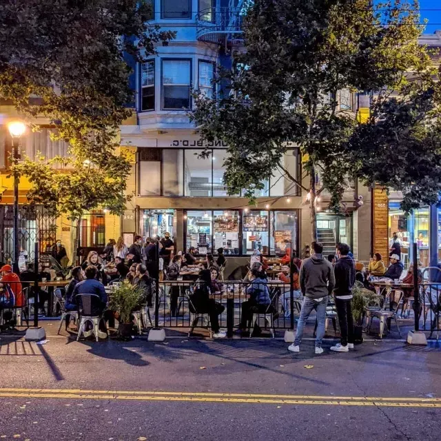 Uma multidão desfruta de 和ida e bebida ao longo da Valencia Street, em 贝博体彩app
