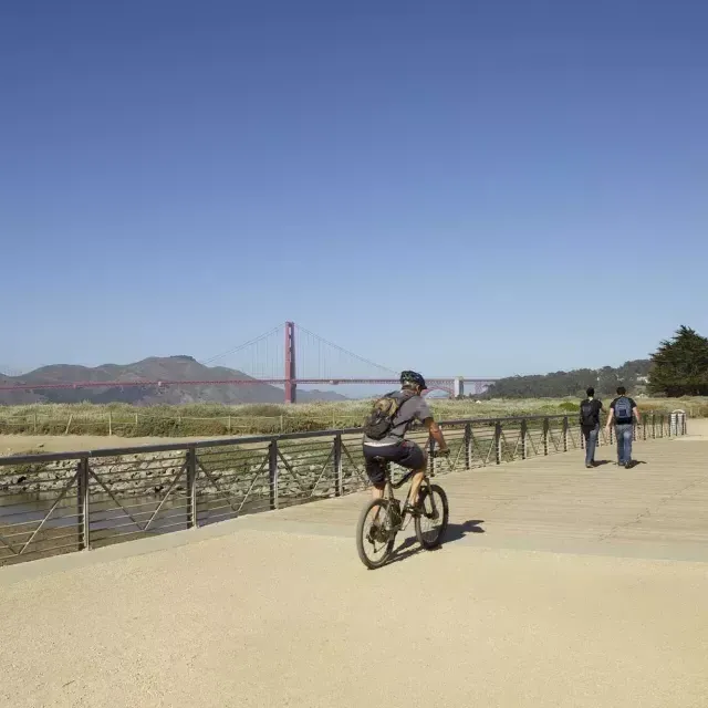 Um homem anda de bicicleta por uma trilha em Crissy Field. São Francisco, Califórnia.