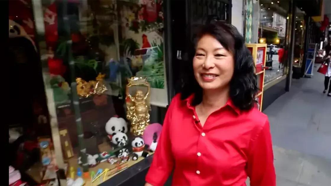 琳达·李穿过唐人街的街道，穿着一件红色的衬衫. 加州贝博体彩app.